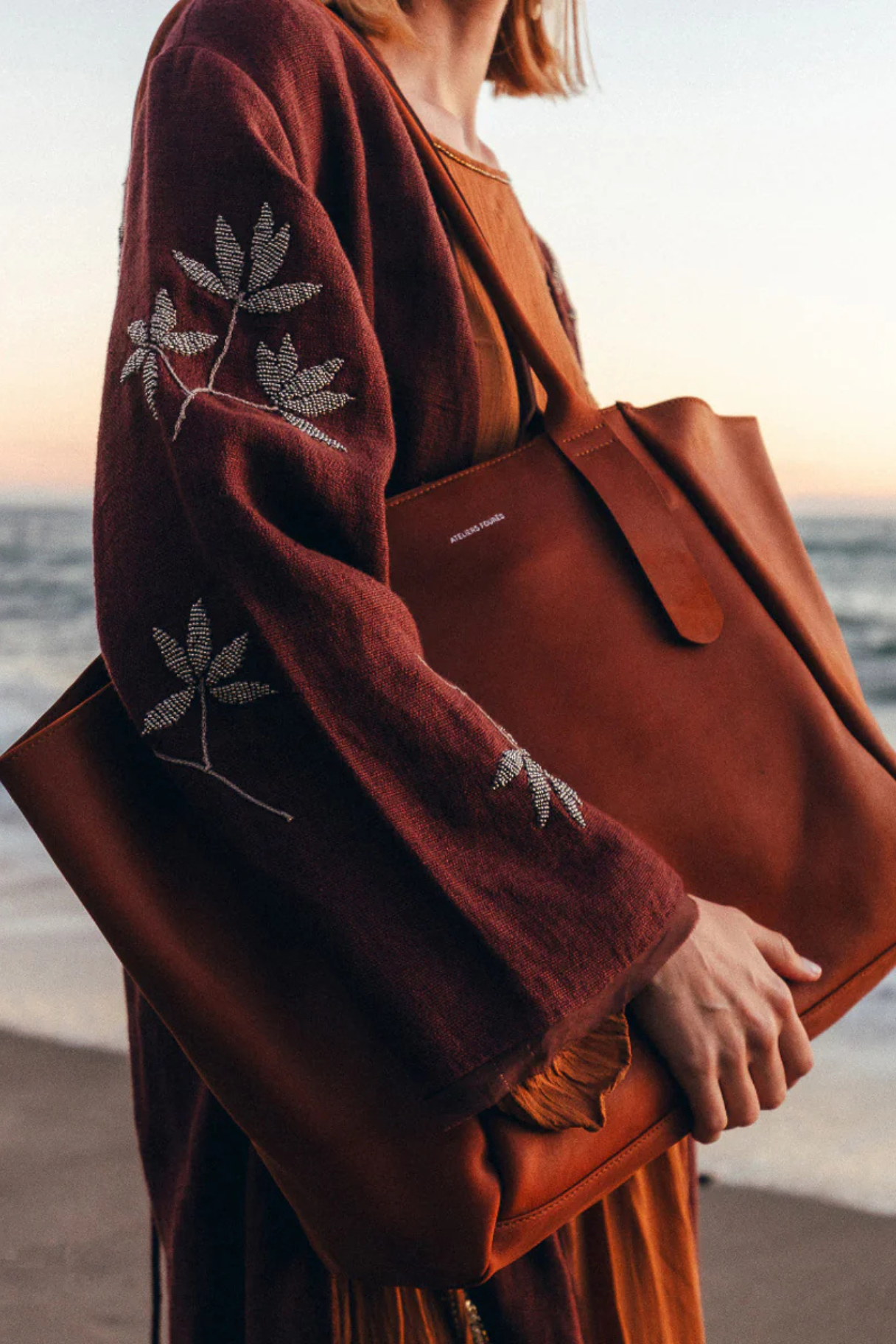 Cabas femme cuir marron Déméter Ateliers Fourès porté à l'épaule au coucher du soleil