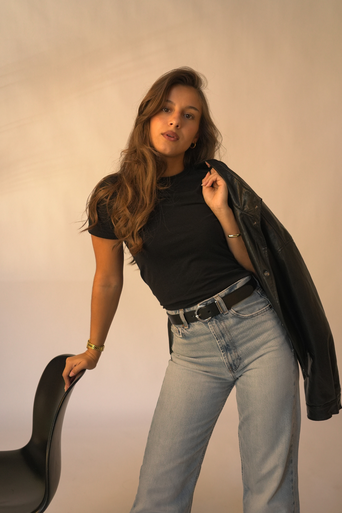 Ceinture femme en cuir noir Céléna Atelier Nappa à boucle ronde et passant argentés, portée avec un jean clair et une veste en cuir