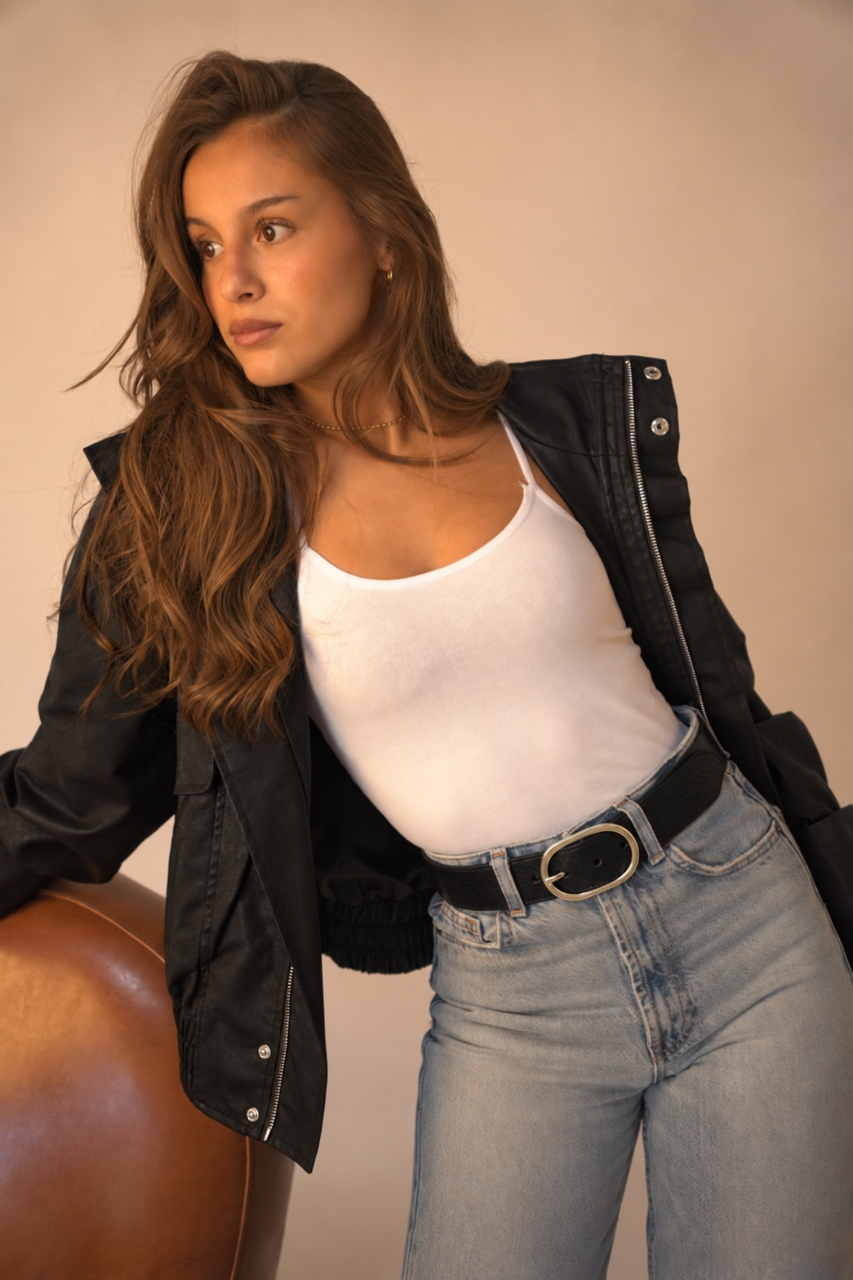 Ceinture Louise Atelier Nappa en cuir noir à boucle ovale argentée, portée sur un jean