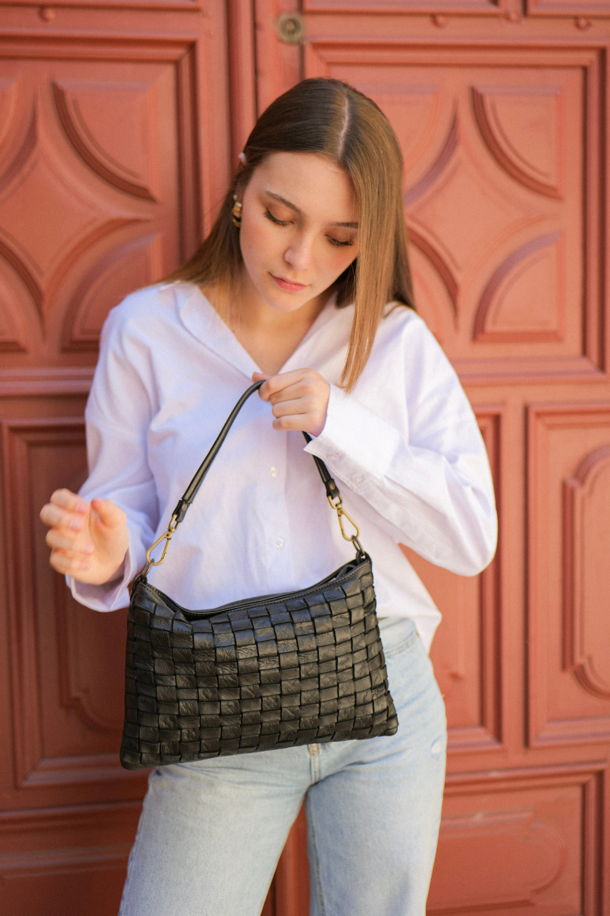 pochette BS-238 en cuir tressé noir portée à la main