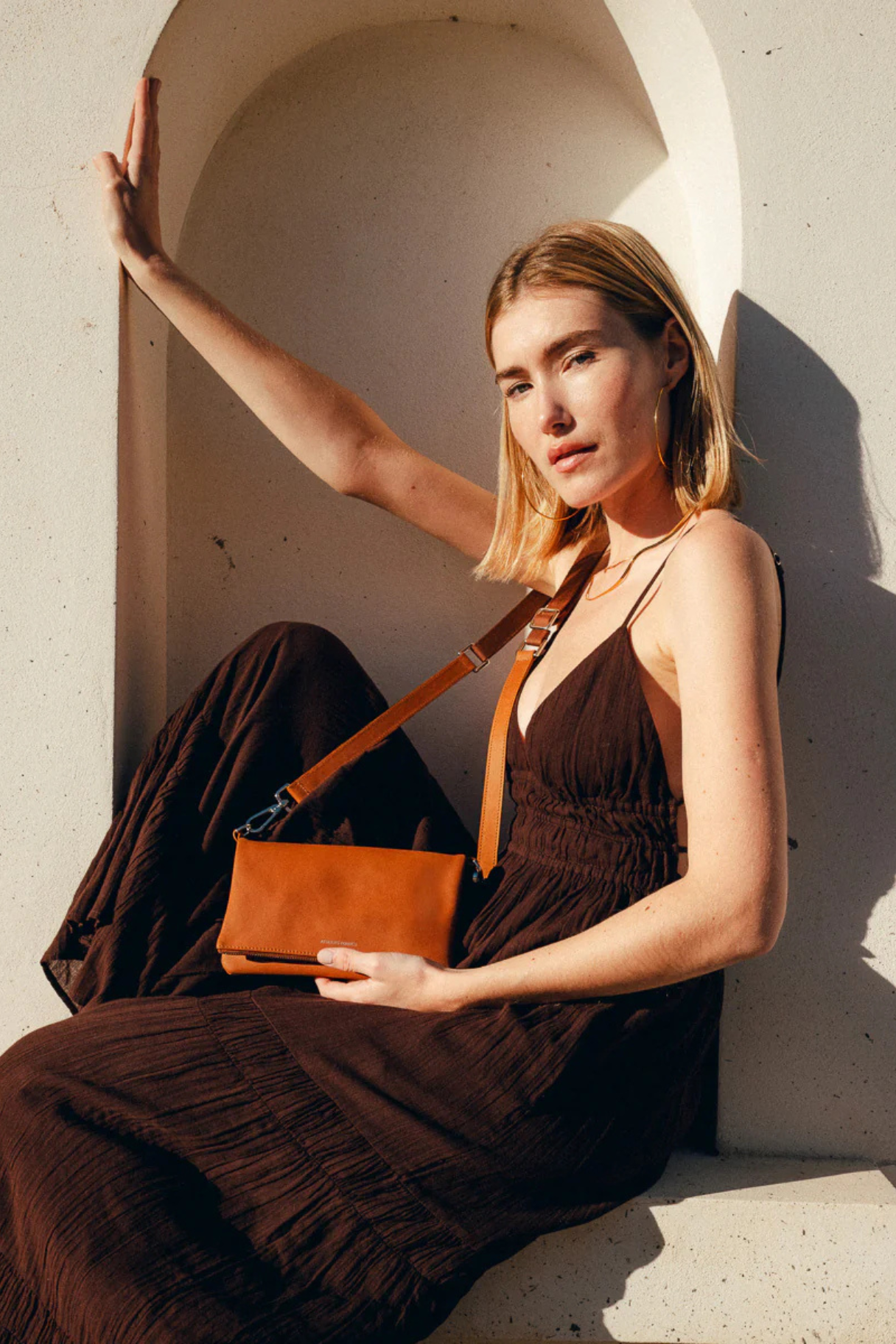 Pochette femme cuir cognac Mycène Ateliers Fourès portée en bandoulière croisée par mannequin