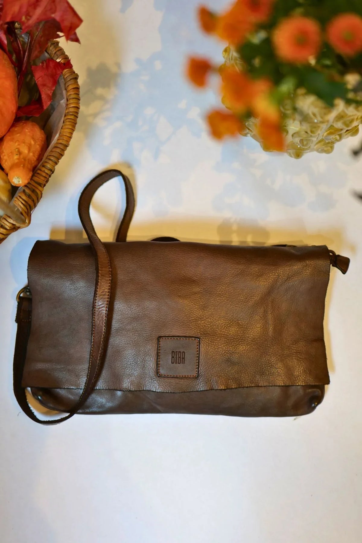 Détail du rabat en cuir marron foncé et de l’étiquette Biba du sac Boston BT5