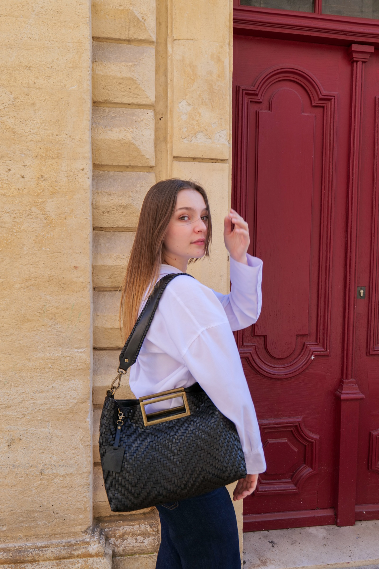 Sac noir tressé à la main BIBA porté à l’épaule avec sangle large