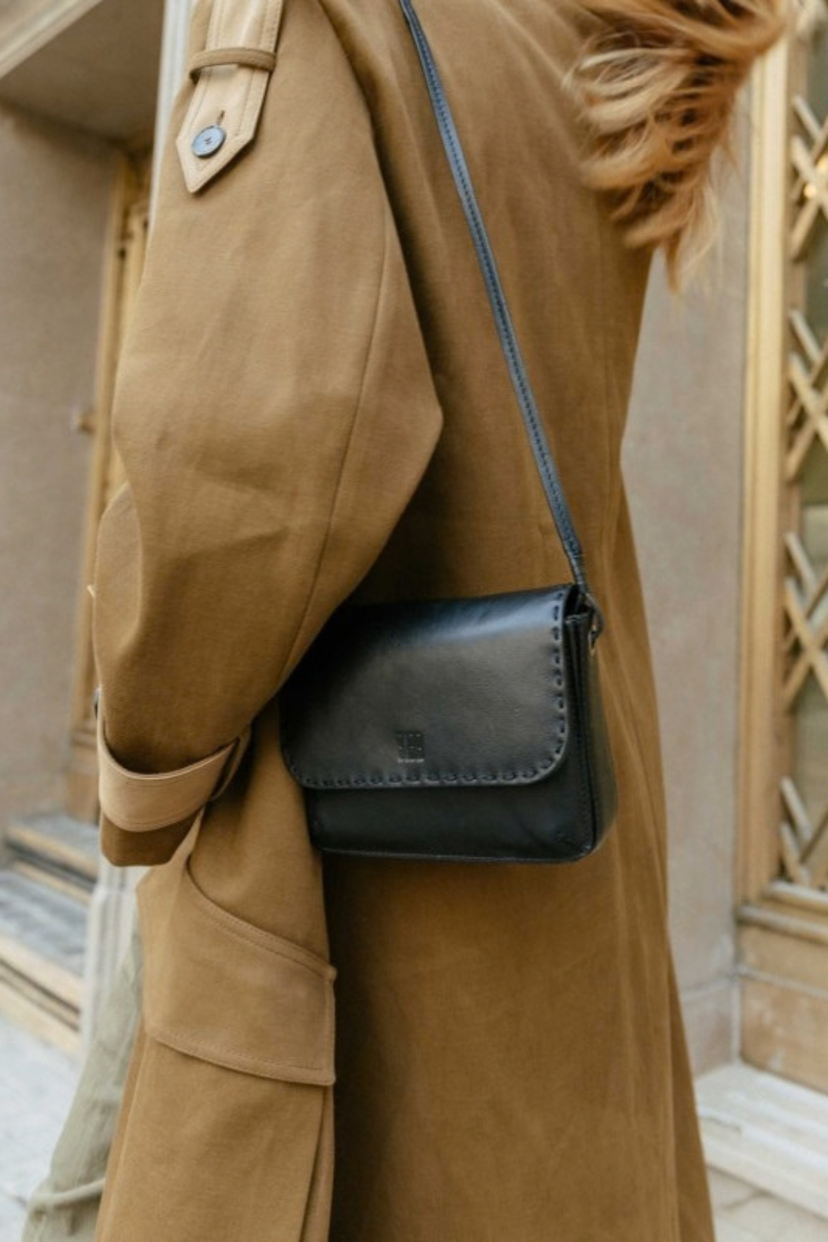 Sac Hatch Biba réf. HAH1L en cuir noir porté en bandoulière croisée avec un trench camel