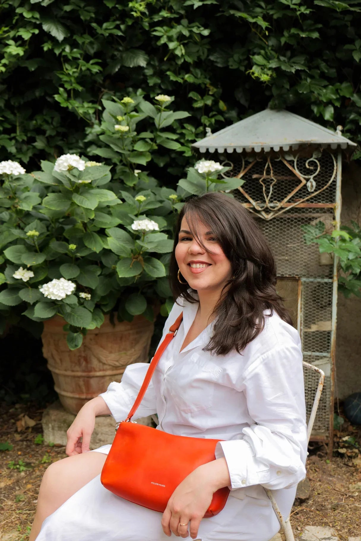 Femme assise avec le sac Iliade orange Ateliers Fourès