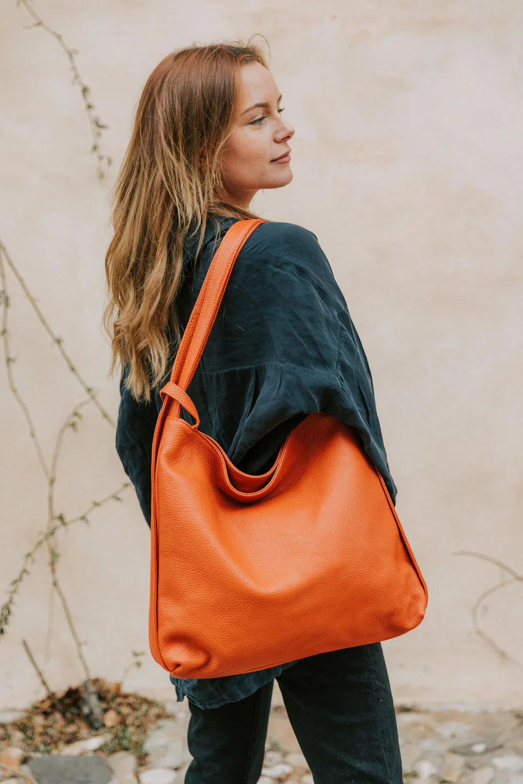 Sac à main convertible Jérôme en cuir grainé orange porté à l'épaule