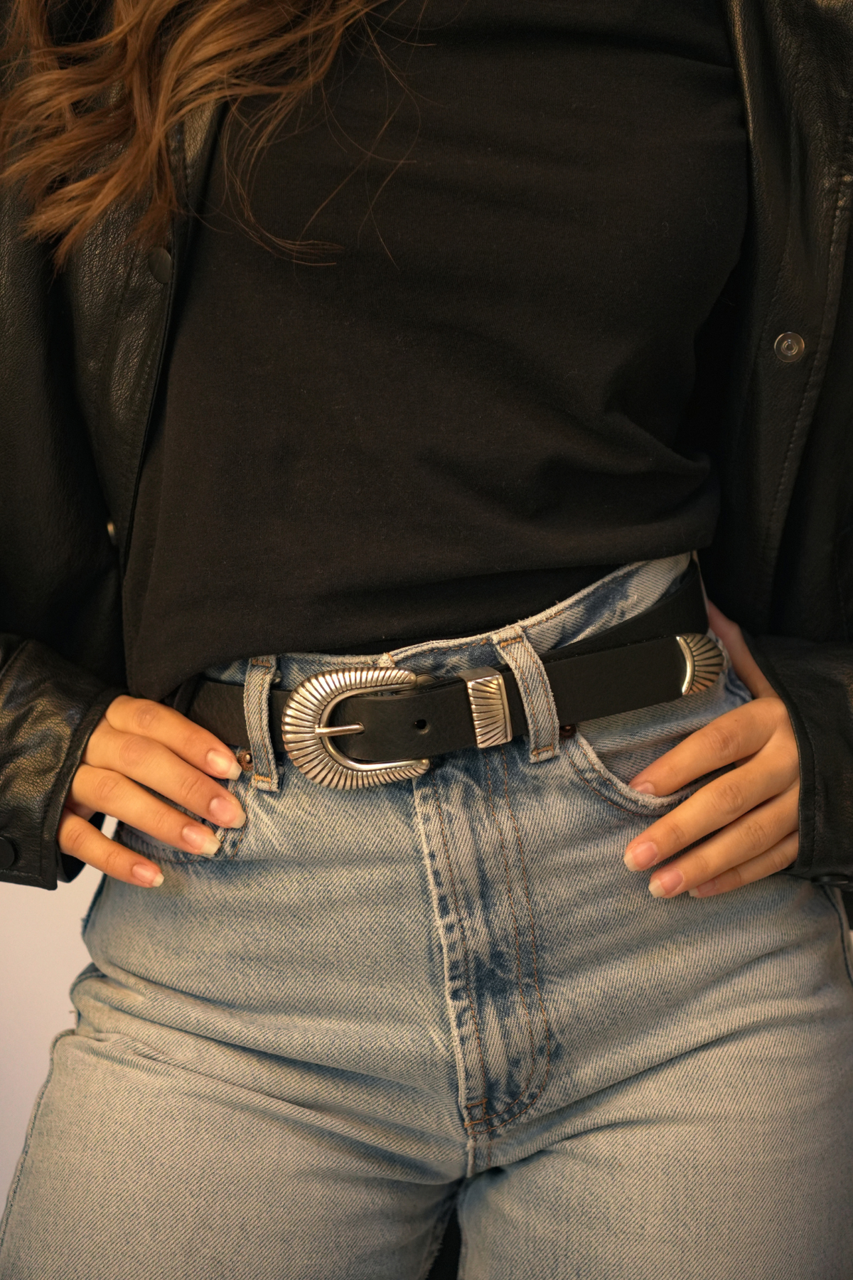 Ceinture femme western en cuir noir Anne Atelier Nappa, portée avec un jean clair, un t-shirt noir et une veste en cuir
