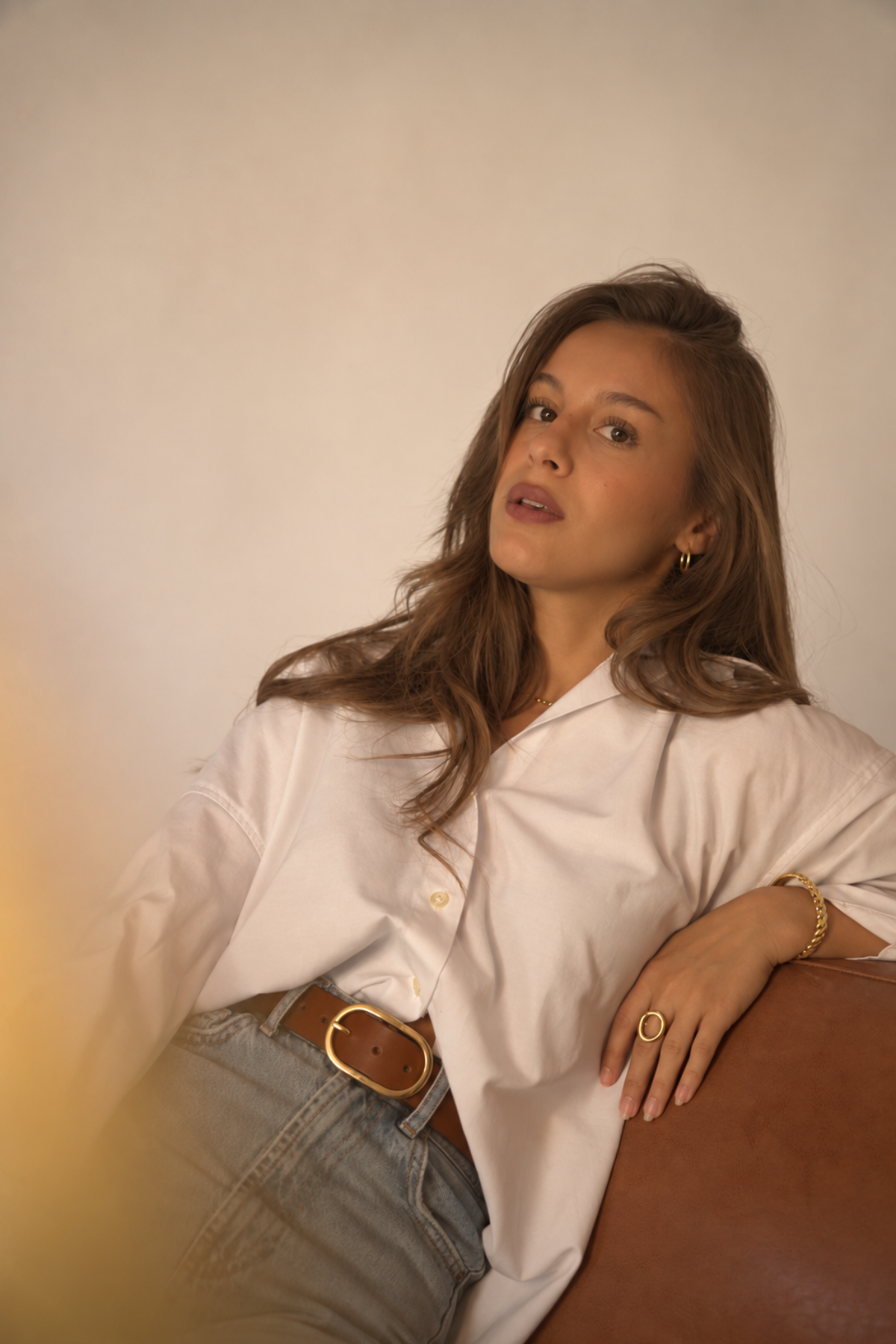 Ceinture large en cuir cognac Louise Atelier Nappa, boucle ovale dorée brillante portée sur un jean clair