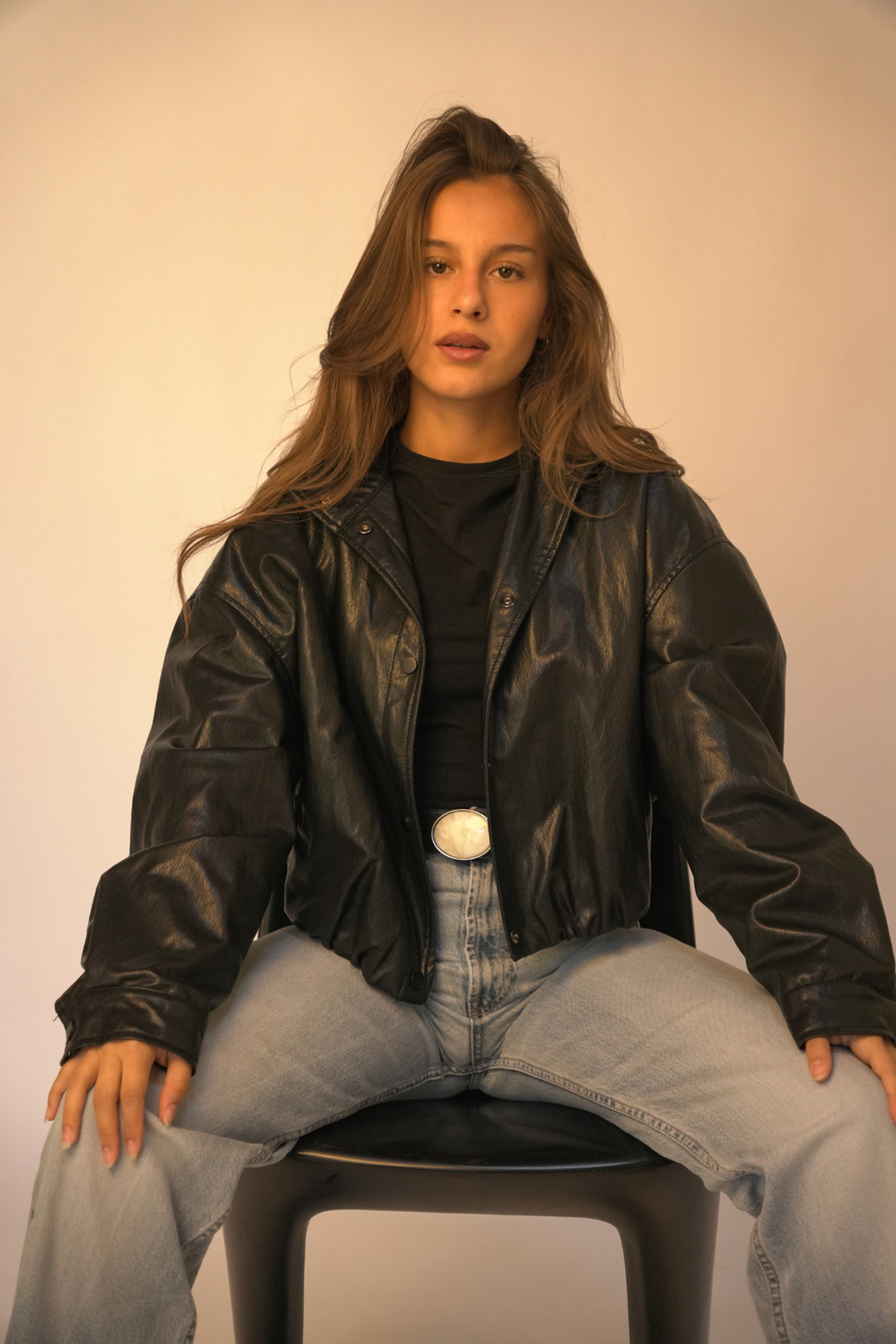 Ceinture en cuir noir Manar Atelier Nappa portée sur un jean large avec une veste en cuir noir