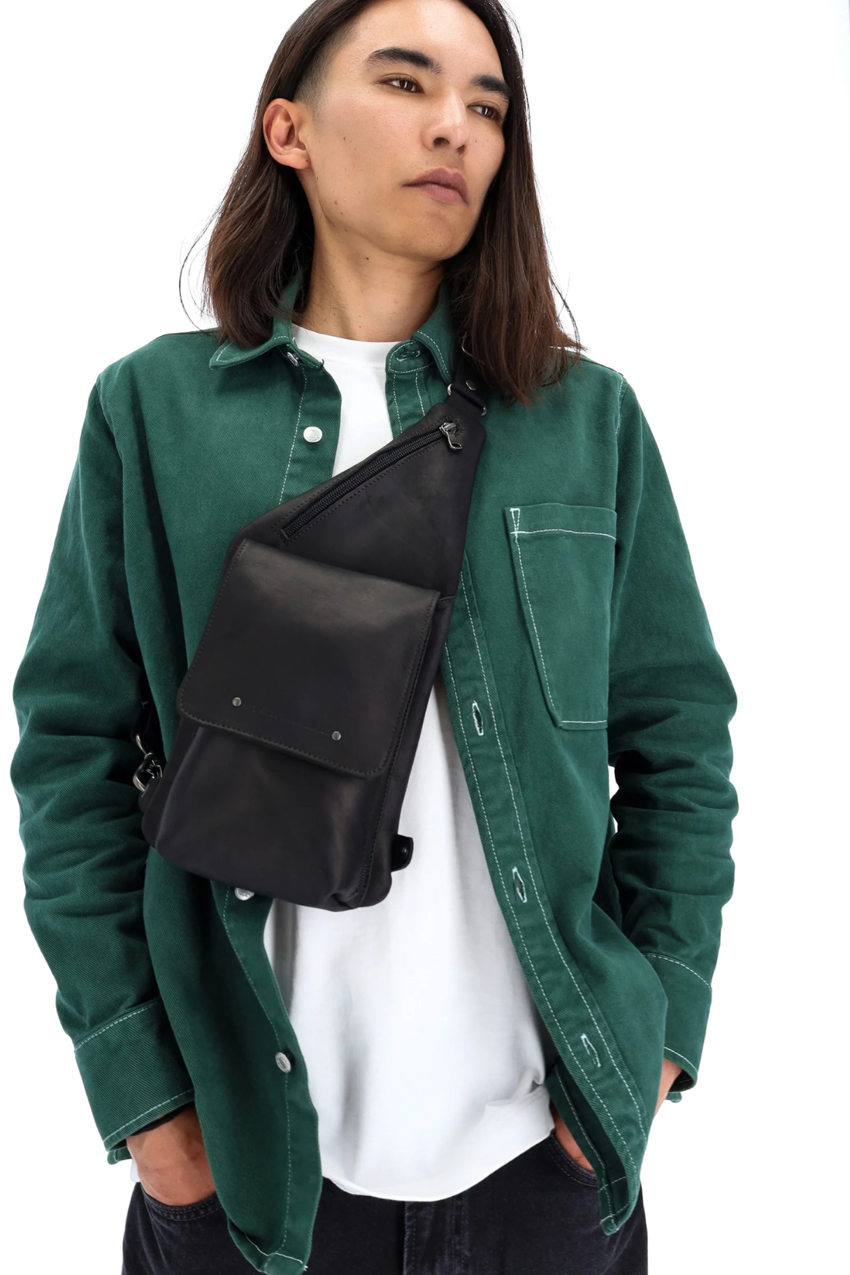 Sling bag cuir noir Dionysos Ateliers Fourès porté contre le buste, made in France