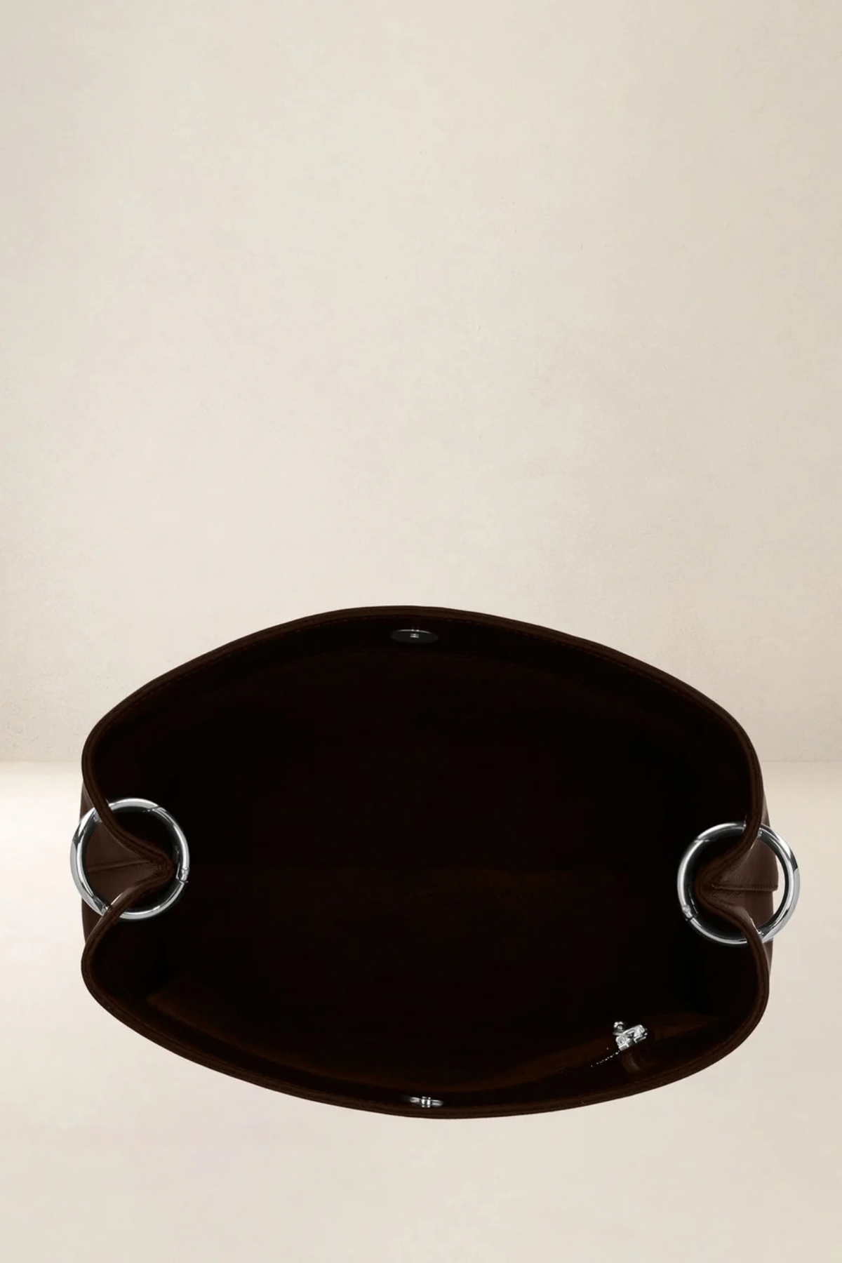 Vue plongeante de l’intérieur du sac seau Alceste Maxi, grande poche principale et anneaux argentés