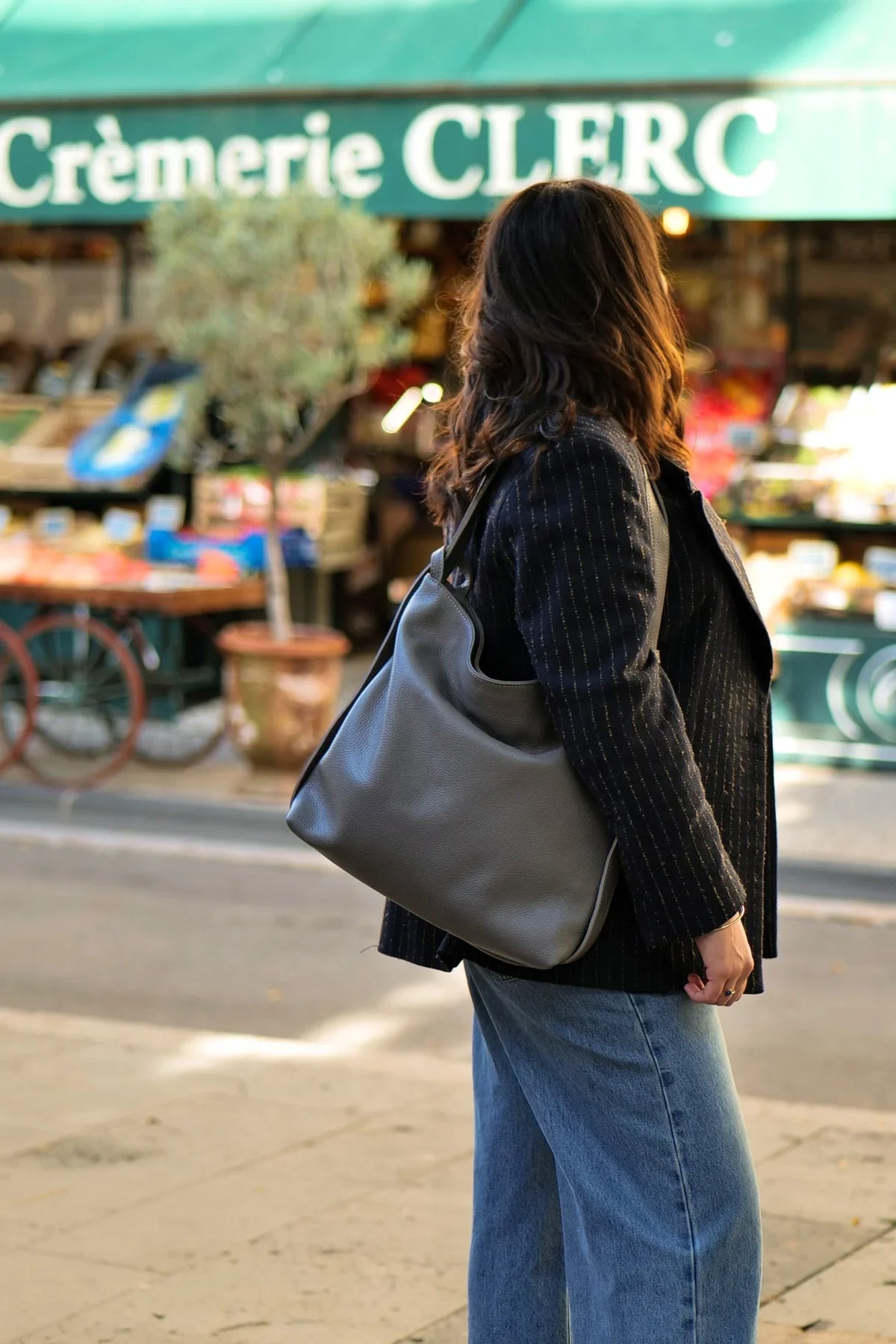 Sac à main convertible Jérôme en cuir grainé gris clair porté à l'épaule