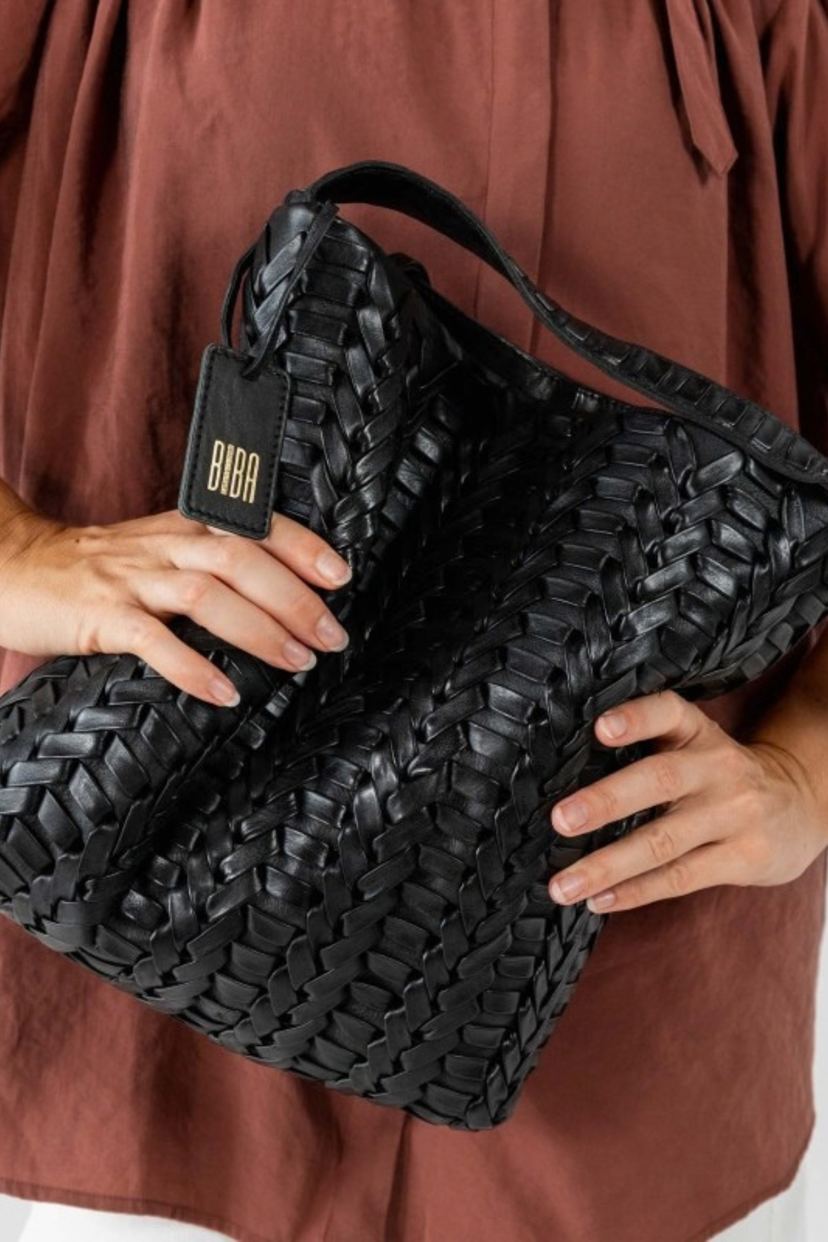 Sac hobo cuir tressé chevron Biba noir portée main 
