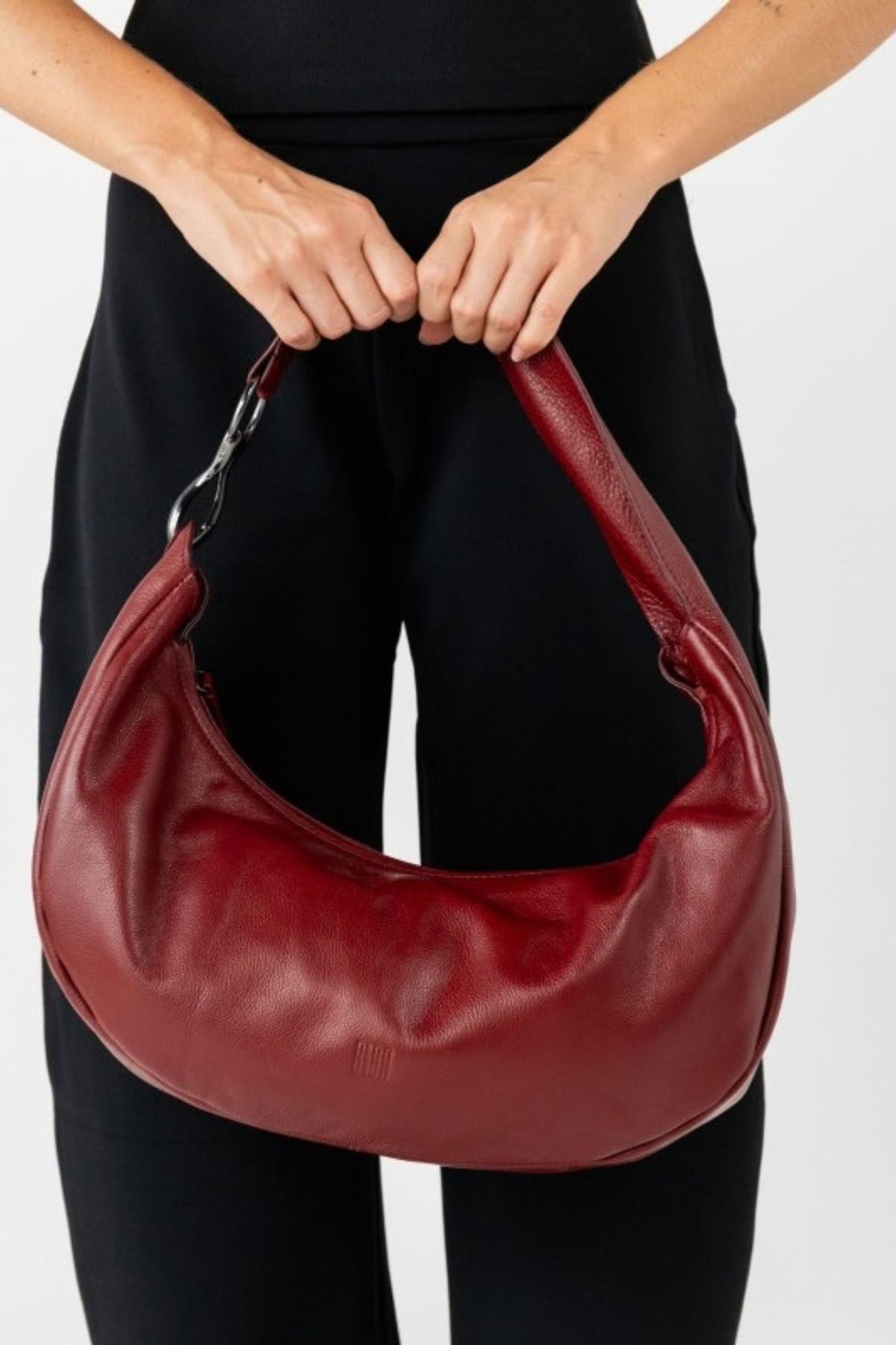 Sac Jackpot Biba bordeaux tenu par son anse large en cuir