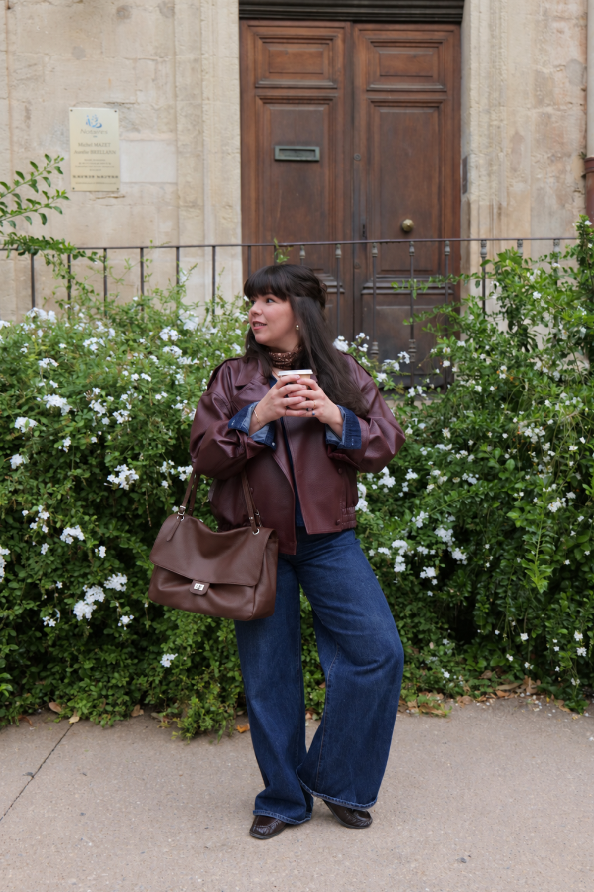 Sac Margot format moyen en cuir grainé porté à l’épaule avec un jean large